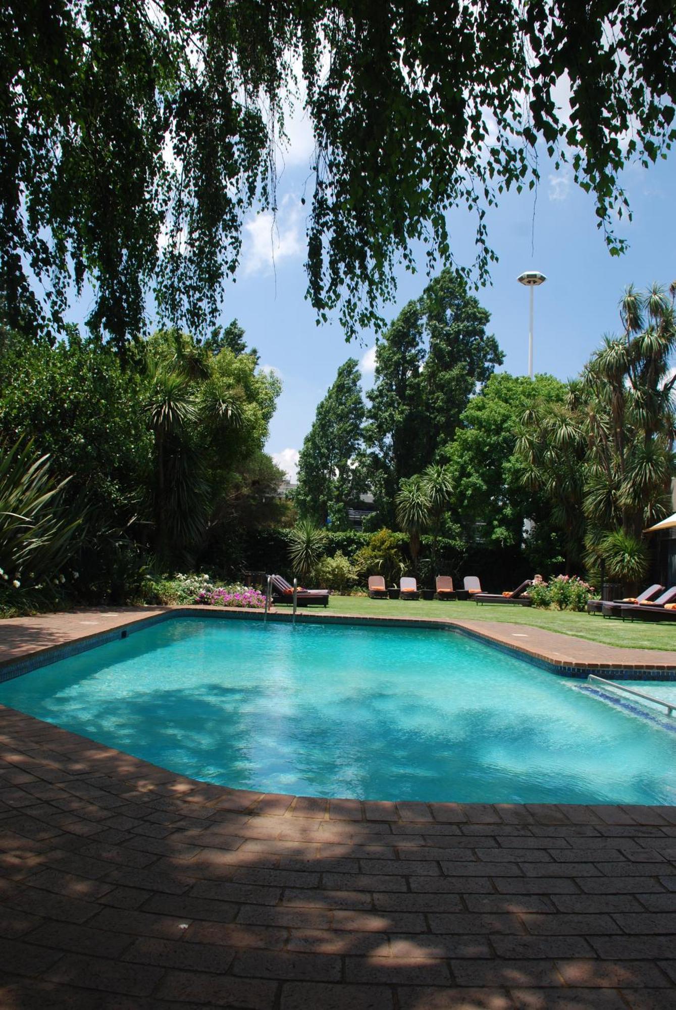 Southern Sun Or Tambo International Airport Kempton Park Zewnętrze zdjęcie The garden and swimming pool at the residence